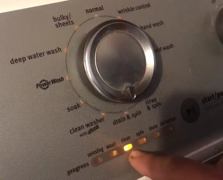 hand pointing to the rinse button on maytag bravos washer